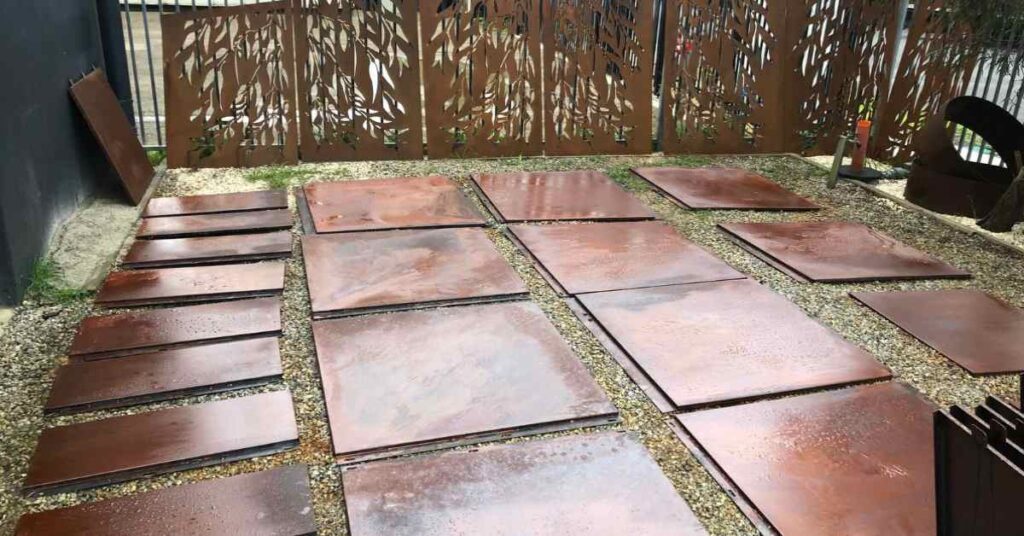 Sheets of Corten steel lying on a front yard.